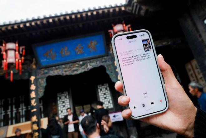 游客在山西古建前用手机体验豆包 AI 讲解。图源：南方都市报